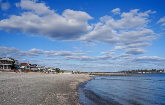 Beautiful coastal scene with beach houses and a blue sky filled with clouds.